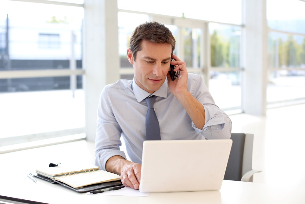 Portrait of businessman talking on mobile phone in office